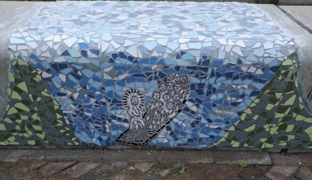 Een zeepatroon in mozaïek op een bankje buiten