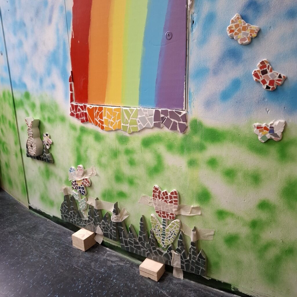 Kleurrijke regenboog mozaïek met dieren op een muur